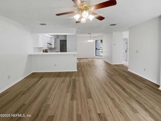1127 Romaine Cir W, Jacksonville, FL 32225 - unfurnished living room with wood finished floors, a ceiling fan, a textured ceiling, and baseboards