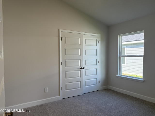 8322 Helmsley Blvd, Jacksonville, FL 32219 - unfurnished bedroom featuring carpet floors, a closet, baseboards, and vaulted ceiling