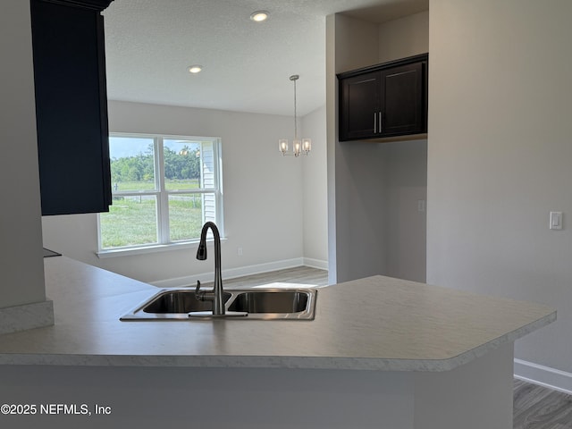 8322 Helmsley Blvd, Jacksonville, FL 32219 - kitchen with a sink, baseboards, wood finished floors, light countertops, and recessed lighting
