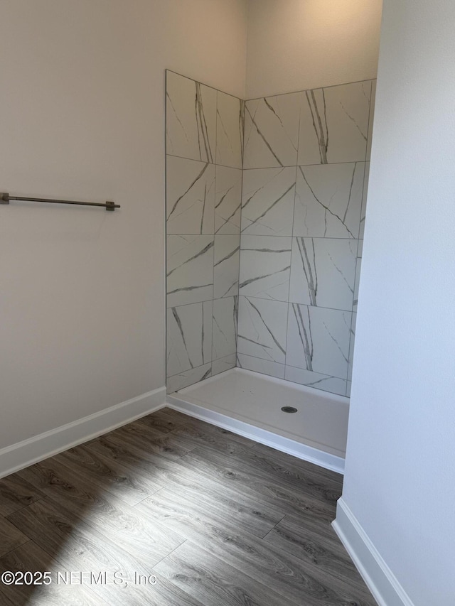8322 Helmsley Blvd, Jacksonville, FL 32219 - bathroom with tiled shower, wood finished floors, and baseboards
