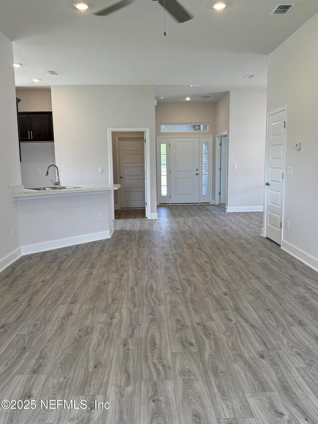 8322 Helmsley Blvd, Jacksonville, FL 32219 - unfurnished living room featuring wood finished floors, ceiling fan, baseboards, recessed lighting, and a sink