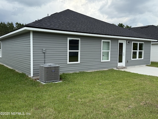 8316 Helmsley Blvd, Jacksonville, FL 32219 - rear view of house featuring central AC unit, roof with shingles, and a lawn