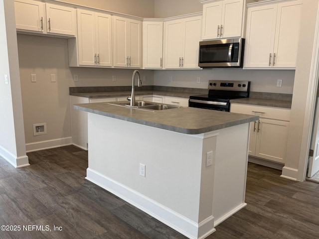 8316 Helmsley Blvd, Jacksonville, FL 32219 - kitchen with stainless steel appliances, a sink, dark wood-style floors, white cabinets, and an island with sink