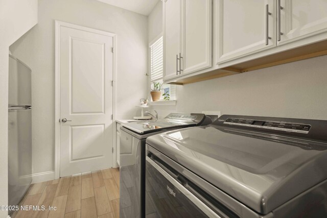 228 Waterline Dr, Saint Johns, FL 32259 - laundry area featuring cabinet space, washer and dryer, light wood-style flooring, and baseboards