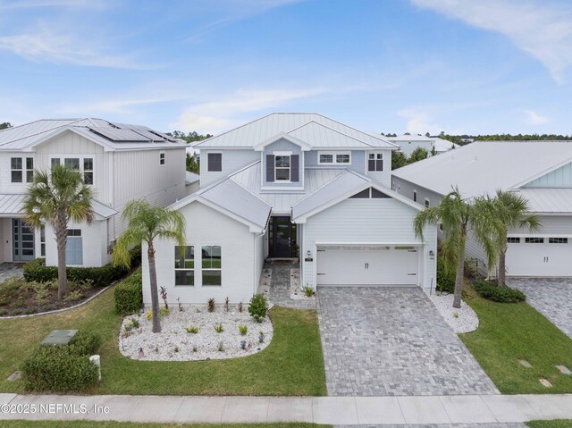 228 Waterline Dr, Saint Johns, FL 32259 - view of front of house featuring decorative driveway, board and batten siding, a front yard, metal roof, and a standing seam roof