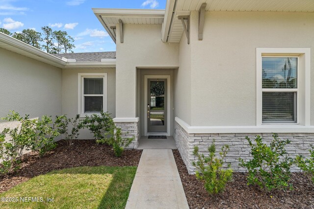 90 Lancelot Dr, Palm Coast, FL 32137 - property entrance with stucco siding, stone siding, and roof with shingles