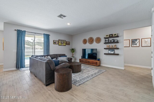 90 Lancelot Dr, Palm Coast, FL 32137 - living area with light wood-style floors, a textured ceiling, baseboards, and recessed lighting