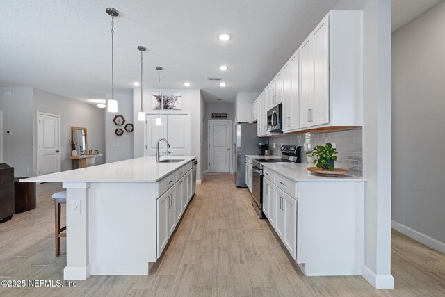 90 Lancelot Dr, Palm Coast, FL 32137 - kitchen featuring appliances with stainless steel finishes, a sink, light wood finished floors, baseboards, and tasteful backsplash