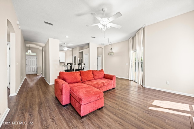 528 Sparrow Branch Cir, Saint Johns, FL 32259 - living area featuring arched walkways, ceiling fan, and dark wood-style flooring