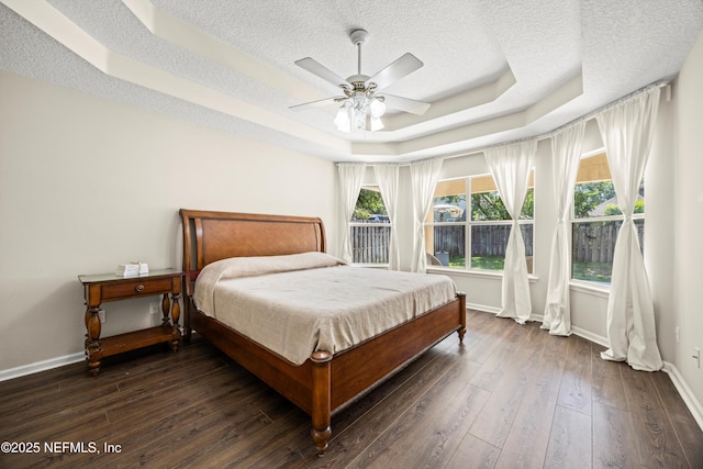 528 Sparrow Branch Cir, Saint Johns, FL 32259 - bedroom with a raised ceiling, baseboards, a textured ceiling, dark wood-style flooring, and multiple windows
