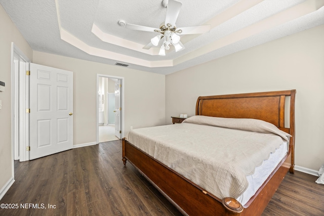 528 Sparrow Branch Cir, Saint Johns, FL 32259 - bedroom with a tray ceiling, wood finished floors, baseboards, ensuite bath, and a ceiling fan