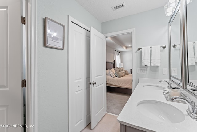 571 Meadow Creek Dr, Saint Johns, FL 32259 - full bath featuring double vanity, connected bathroom, and a textured ceiling