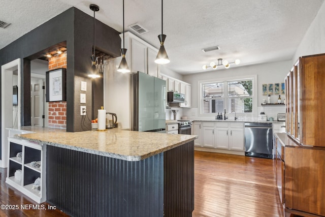 4241 Lexington Ave, Jacksonville, FL 32210 - kitchen with stainless steel appliances, a textured ceiling, a peninsula, light wood finished floors, and open shelves