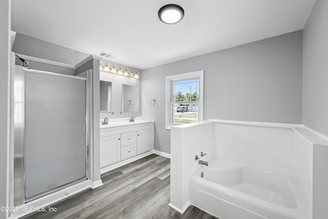 2155 Diana Dr, Palatka, FL 32177 - bathroom featuring a garden tub, double vanity, a shower stall, and wood finished floors