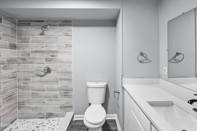 2155 Diana Dr, Palatka, FL 32177 - bathroom with toilet, tiled shower, vanity, and wood finished floors