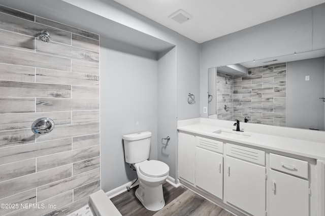 2155 Diana Dr, Palatka, FL 32177 - bathroom with vanity, toilet, tiled shower, wood finished floors, and baseboards