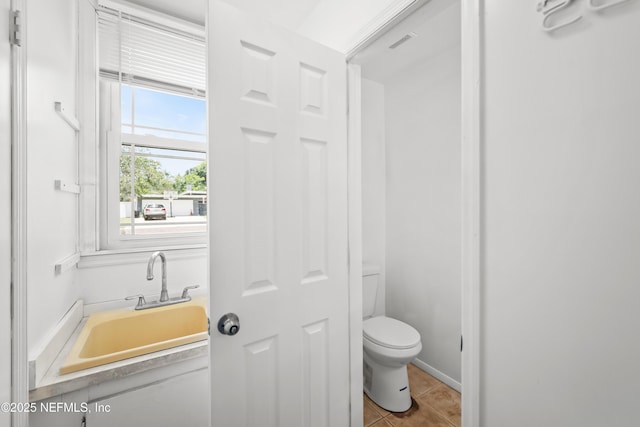 2155 Diana Dr, Palatka, FL 32177 - bathroom with toilet, a sink, and tile patterned flooring