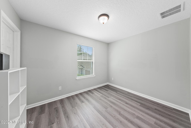 8609 Victoria Falls Dr, Jacksonville, FL 32244 - spare room with wood finished floors, a textured ceiling, and baseboards