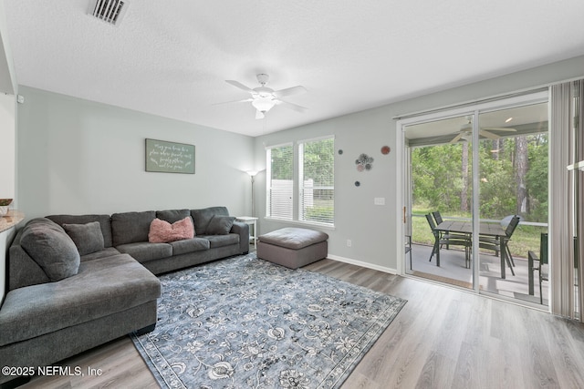 8609 Victoria Falls Dr, Jacksonville, FL 32244 - living room featuring ceiling fan, wood finished floors, baseboards, and a textured ceiling