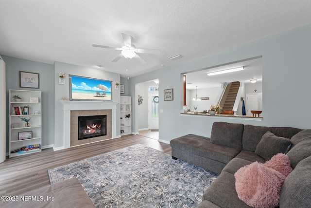 8609 Victoria Falls Dr, Jacksonville, FL 32244 - living area with wood finished floors, ceiling fan, a tile fireplace, baseboards, and built in features