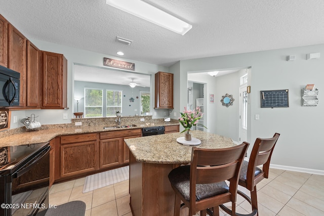 8609 Victoria Falls Dr, Jacksonville, FL 32244 - kitchen featuring black appliances, a sink, brown cabinetry, a center island, and a textured ceiling