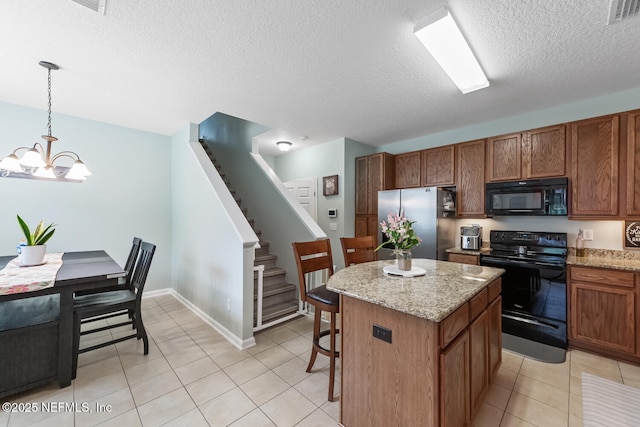 8609 Victoria Falls Dr, Jacksonville, FL 32244 - kitchen with black appliances, a chandelier, a center island, light tile patterned flooring, and a breakfast bar area