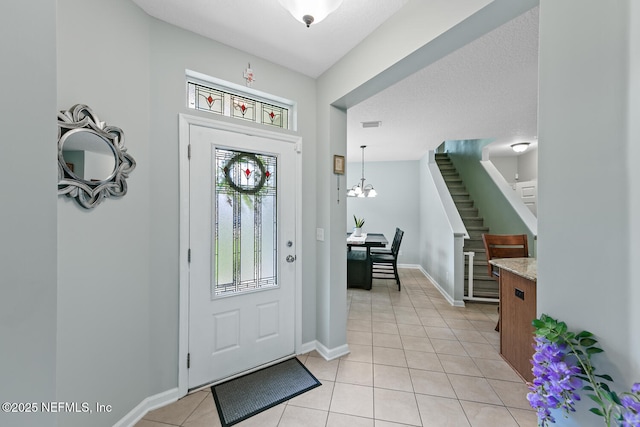 8609 Victoria Falls Dr, Jacksonville, FL 32244 - foyer featuring light tile patterned floors, stairs, baseboards, and a chandelier
