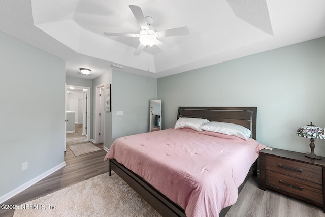 8609 Victoria Falls Dr, Jacksonville, FL 32244 - bedroom featuring wood finished floors, baseboards, a tray ceiling, and a ceiling fan