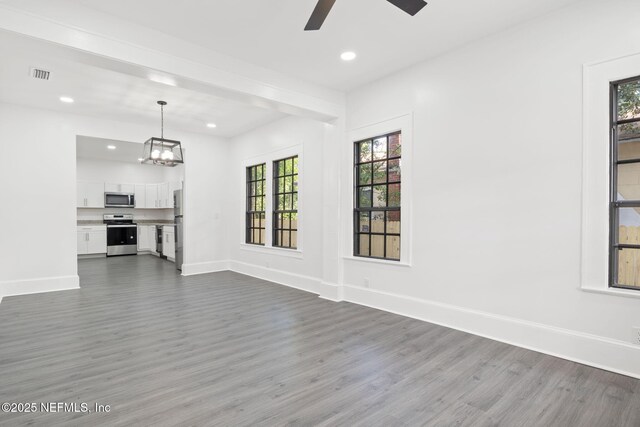 3918 Springfield Blvd, Jacksonville, FL 32206 - unfurnished living room featuring dark wood-type flooring, a ceiling fan, baseboards, recessed lighting, and a chandelier