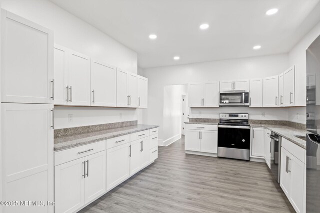 3918 Springfield Blvd, Jacksonville, FL 32206 - kitchen with appliances with stainless steel finishes, white cabinetry, recessed lighting, light wood-style flooring, and light stone countertops