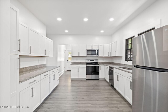 3918 Springfield Blvd, Jacksonville, FL 32206 - kitchen featuring appliances with stainless steel finishes, a sink, recessed lighting, white cabinets, and light stone counters