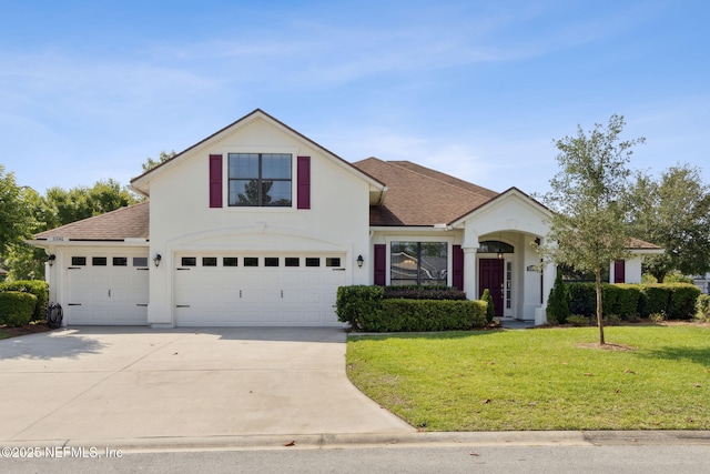 33146 Prairie Parke Pl, Fernandina Beach, FL 32034 - traditional-style home featuring a shingled roof, driveway, a front lawn, and stucco siding