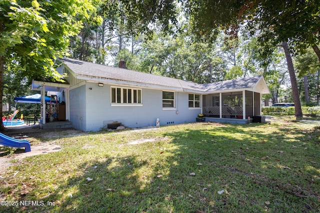 2780 Paul Ave, Jacksonville, FL 32207 - back of house featuring a sunroom, a chimney, a playground, concrete block siding, and a lawn