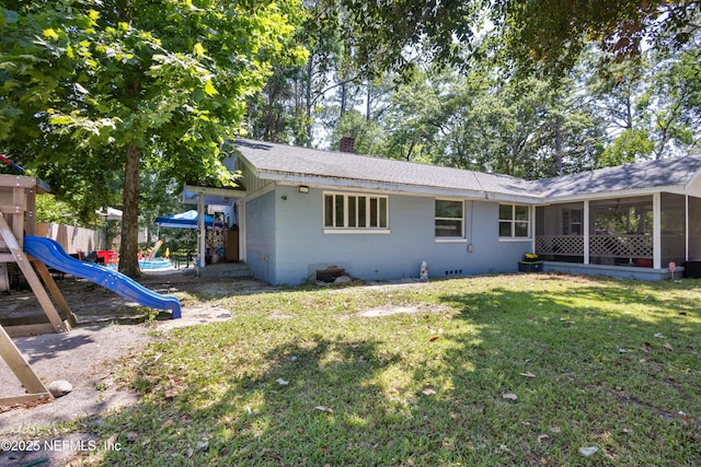 2780 Paul Ave, Jacksonville, FL 32207 - rear view of property with a playground, a sunroom, concrete block siding, a lawn, and a chimney