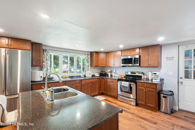 2780 Paul Ave, Jacksonville, FL 32207 - kitchen with appliances with stainless steel finishes, a sink, light wood-style flooring, brown cabinetry, and recessed lighting