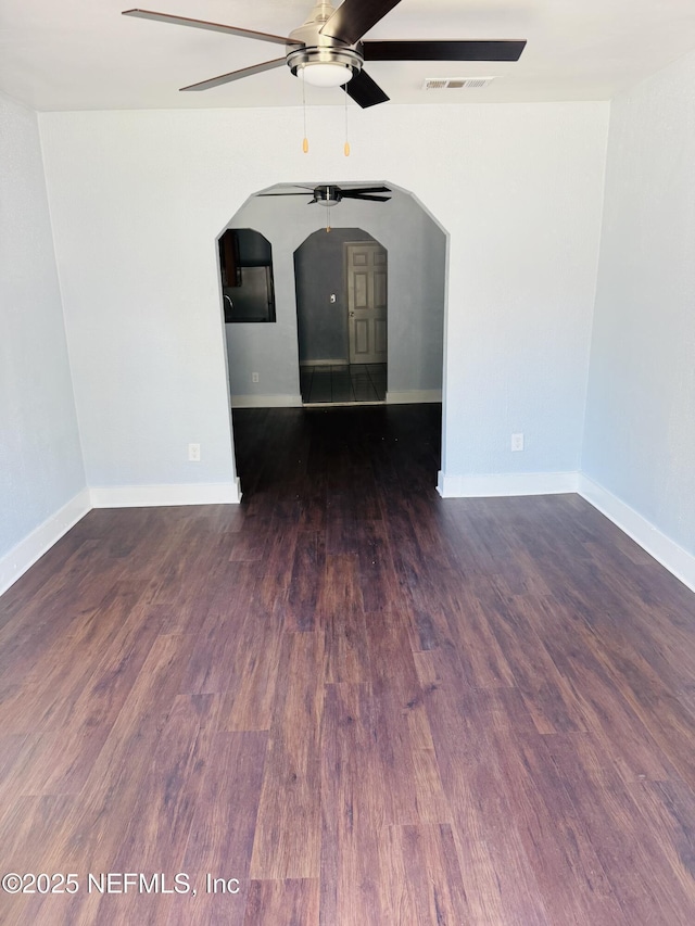 1556 Logan St, Jacksonville, FL 32209 - spare room featuring ceiling fan, arched walkways, wood finished floors, and baseboards