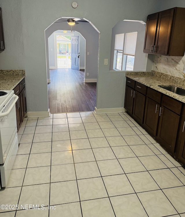 1556 Logan St, Jacksonville, FL 32209 - kitchen with healthy amount of natural light, arched walkways, dark brown cabinetry, and a textured wall