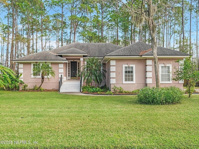 96092 Piney Island Dr, Fernandina Beach, FL 32034 - view of front of home with stucco siding, a front yard, and roof with shingles