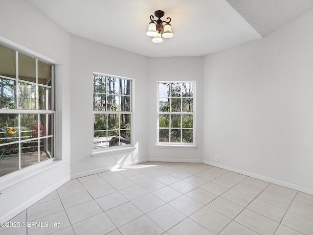 96092 Piney Island Dr, Fernandina Beach, FL 32034 - empty room featuring a chandelier, light tile patterned flooring, and baseboards