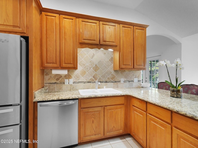 96092 Piney Island Dr, Fernandina Beach, FL 32034 - kitchen featuring appliances with stainless steel finishes, a sink, tasteful backsplash, light stone counters, and lofted ceiling