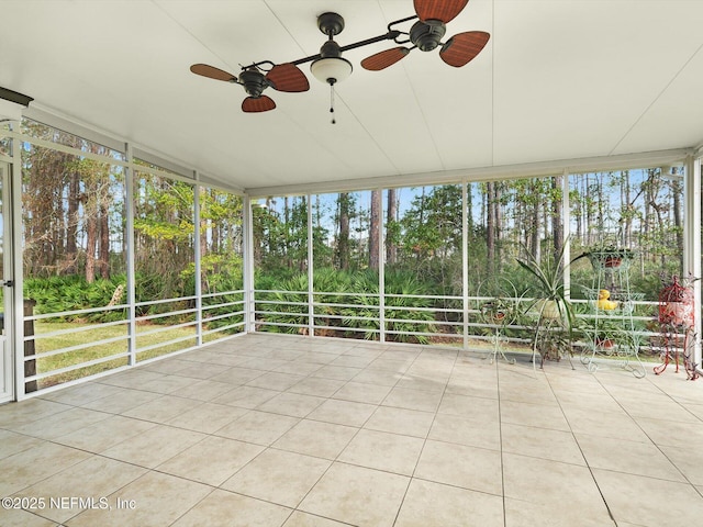 96092 Piney Island Dr, Fernandina Beach, FL 32034 - unfurnished sunroom featuring a ceiling fan, a wall of windows, view of scattered trees, and tile patterned flooring