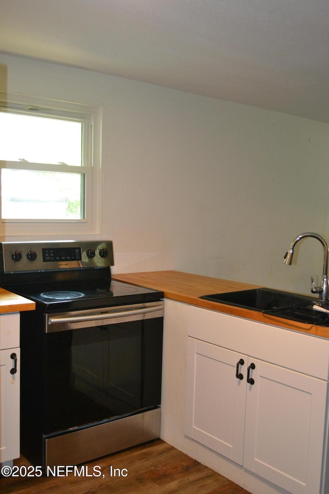 5466 Leonard St, Fernandina Beach, FL 32034 - kitchen featuring electric stove, a sink, white cabinetry, and wood finished floors
