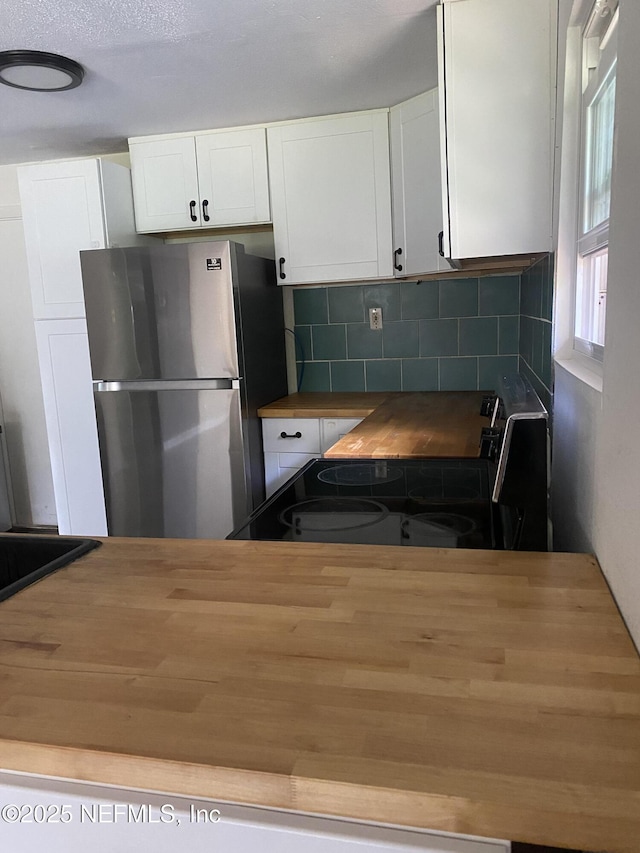 5466 Leonard St, Fernandina Beach, FL 32034 - kitchen featuring freestanding refrigerator, wood counters, electric stove, backsplash, and white cabinetry