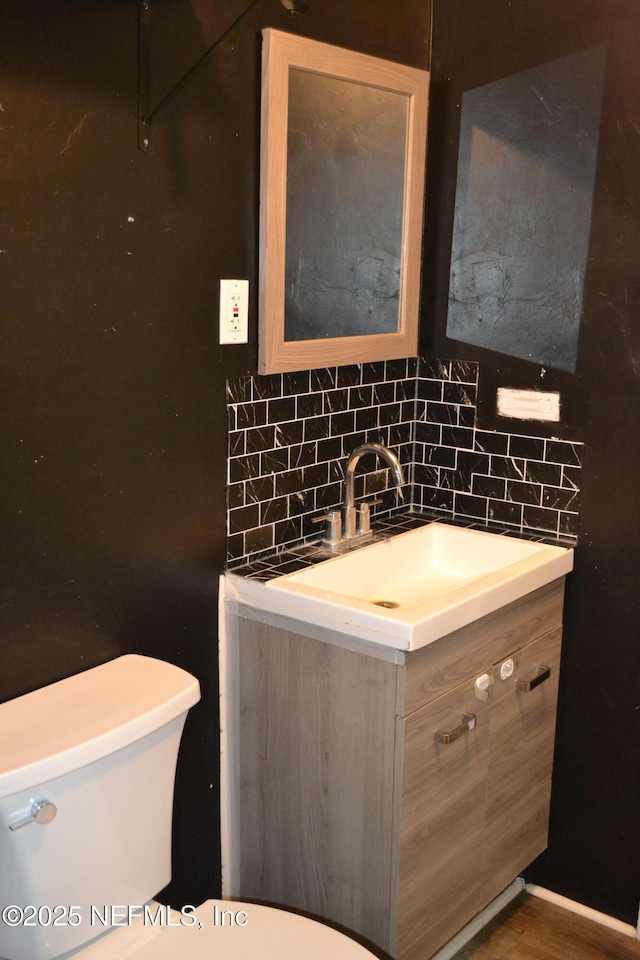 5466 Leonard St, Fernandina Beach, FL 32034 - half bathroom with vanity, toilet, and backsplash