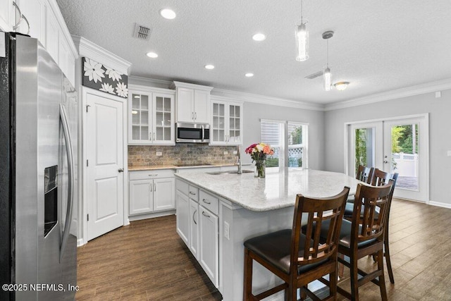 356 Heron Landing Rd, Saint Johns, FL 32259 - kitchen with stainless steel appliances, a sink, crown molding, dark wood-type flooring, and white cabinetry