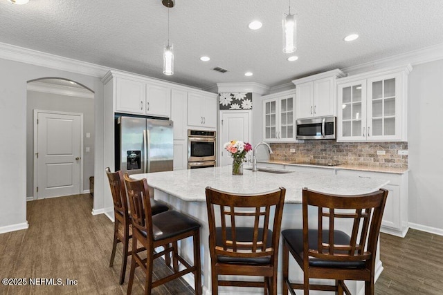 356 Heron Landing Rd, Saint Johns, FL 32259 - kitchen with a sink, stainless steel appliances, arched walkways, white cabinets, and backsplash