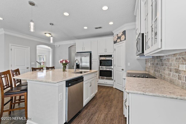 356 Heron Landing Rd, Saint Johns, FL 32259 - kitchen featuring appliances with stainless steel finishes, a sink, arched walkways, crown molding, and white cabinets