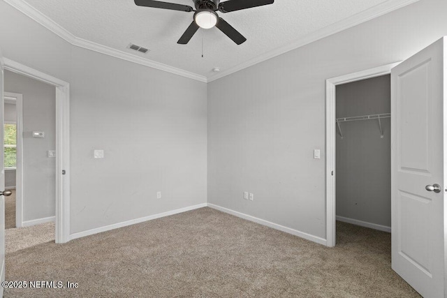356 Heron Landing Rd, Saint Johns, FL 32259 - unfurnished bedroom featuring carpet floors, crown molding, a walk in closet, a closet, and a textured ceiling