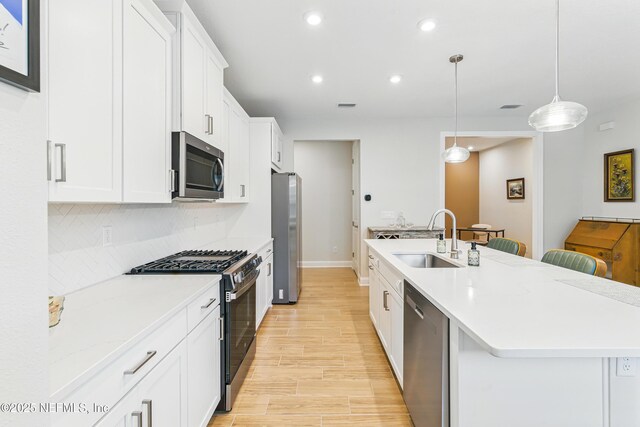 109 Fly Line Dr, Saint Johns, FL 32259 - kitchen with appliances with stainless steel finishes, a sink, an island with sink, recessed lighting, and white cabinetry