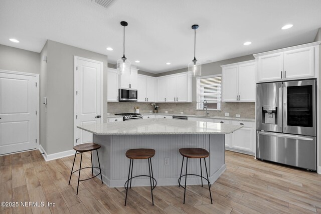 91 Rockhurst Trl, Jacksonville, FL 32081 - kitchen with stainless steel appliances, a sink, white cabinets, a center island, and decorative backsplash